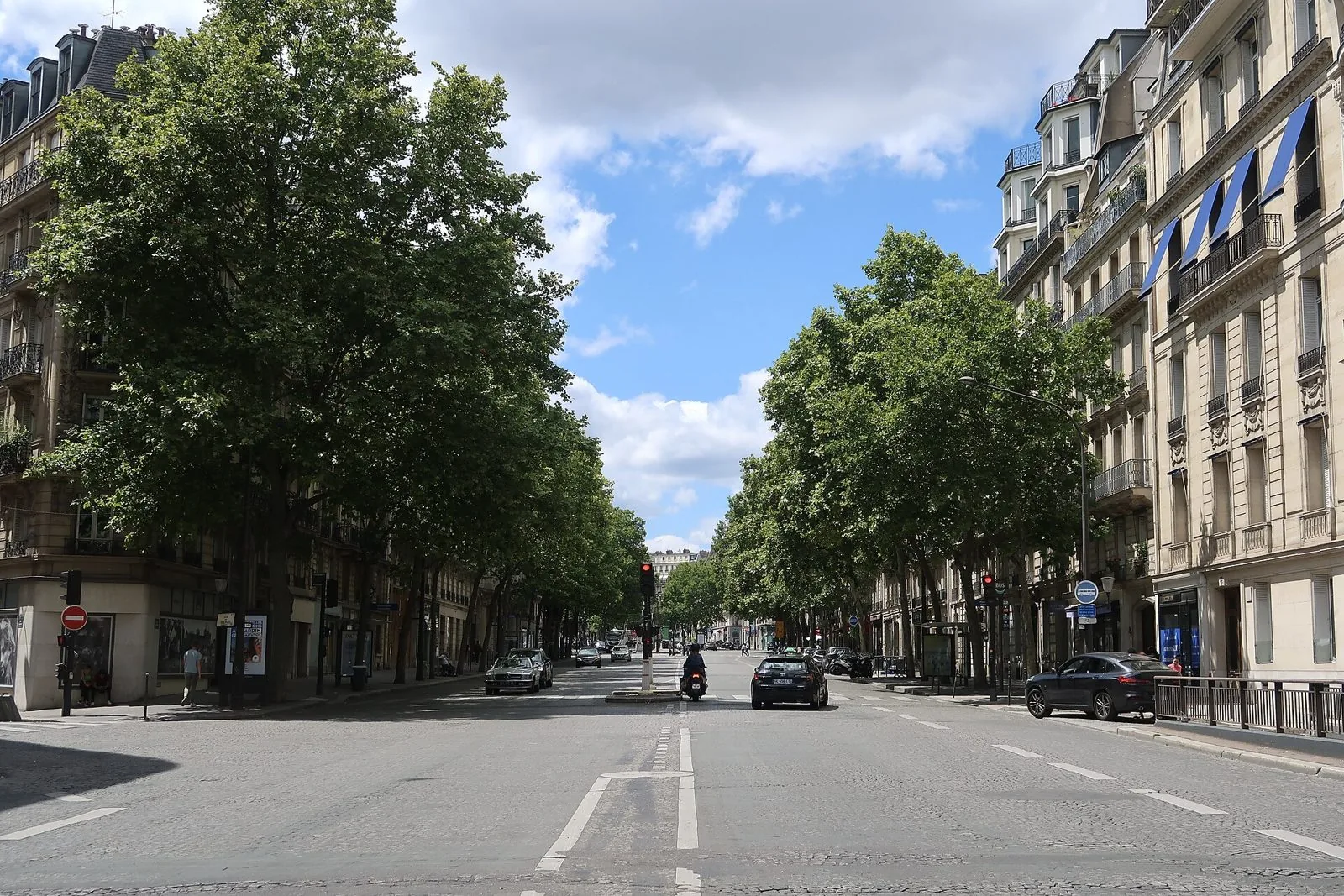 Boulevard Haussmann a Parigi con palazzi ottocenteschi e platani in una giornata di sole